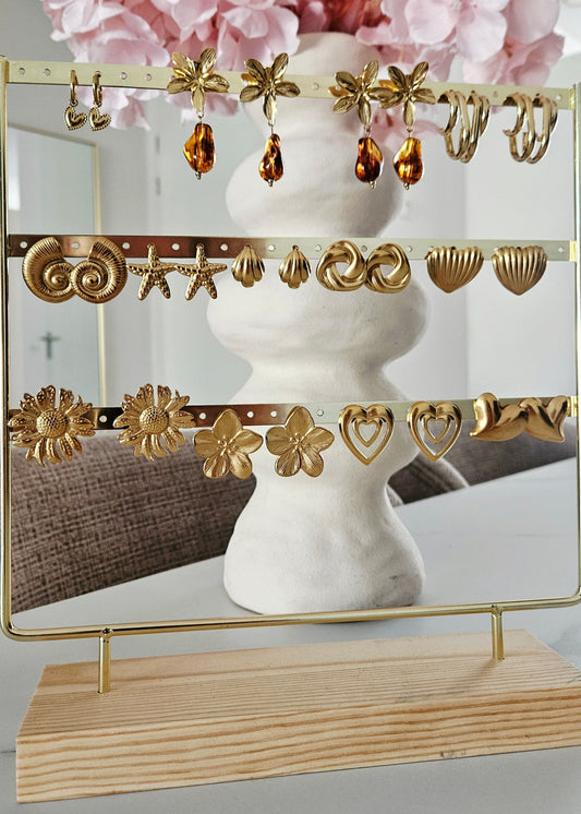 Goudkope zomerse gouden oorbellen op oorbellendisplay