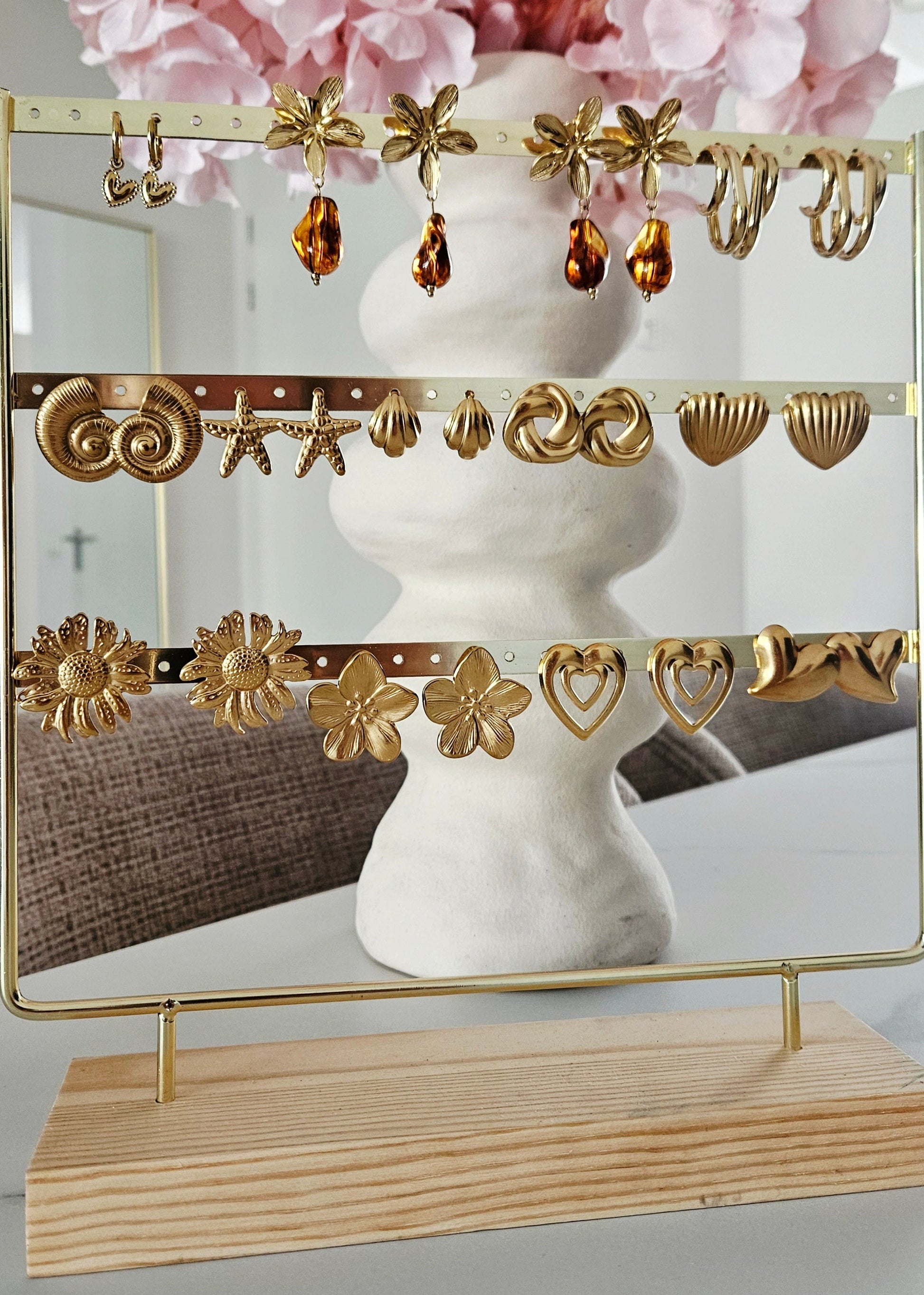 Goudkope zomerse gouden oorbellen op oorbellendisplay