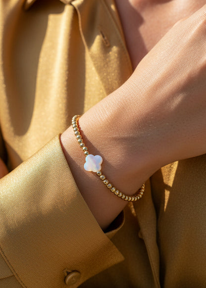 Goud kralenarmbandje met een witte klaver